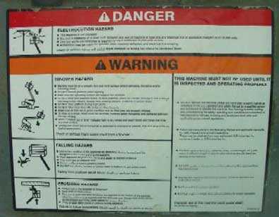The warning label on the aerial platform illustrates the hazards of electrocution, falling, or striking an overhead obstacle.