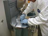 Environmental wipe samples are being collected from the lid of a hamper used for drug-contaminated linen.
