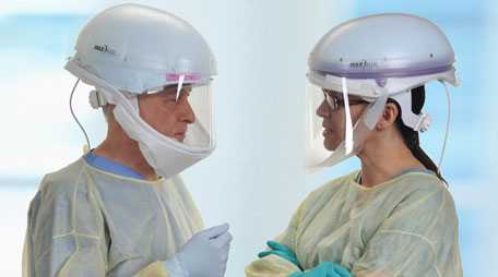 Health care workers wearing powered air-purifying respirators.