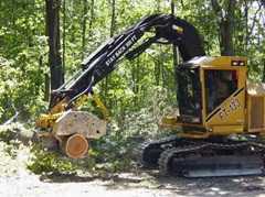	tractor lifting a large tree stump