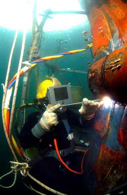 Commercial diver welding under water.