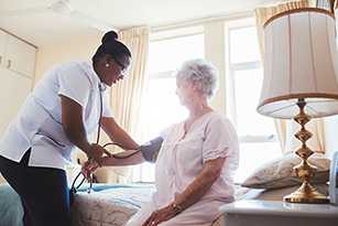 nurse helping older woman