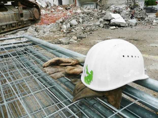 A construction helmet laying on a pair of work gloves