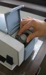 A person's hand reaches into a device with a portable sampling cassette
