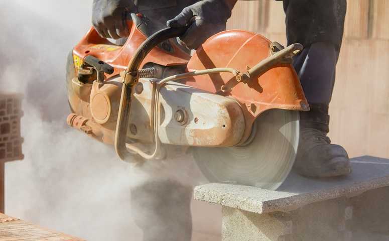 worker cutting brick with a power saw