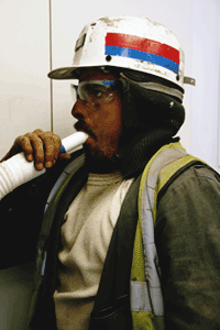 A miner blowing into a tube for lung function testing