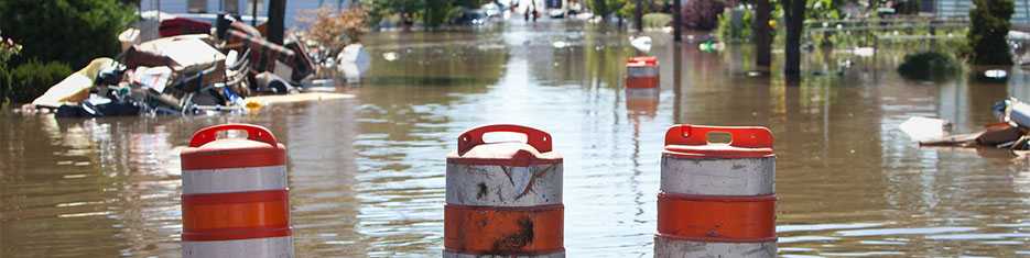 Floating orange caution barrels in a flood area
