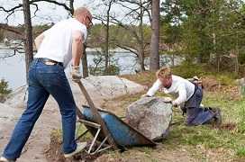 one man dumping a huge boulder and another man retrieving it - awkward postures