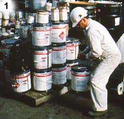 	Worker lifting paint cans stacked on pallet