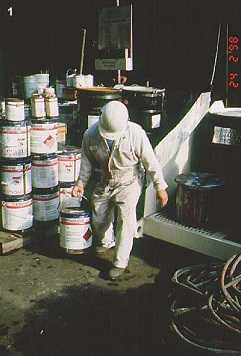 	Worker carrying heavy paint cans one-handed