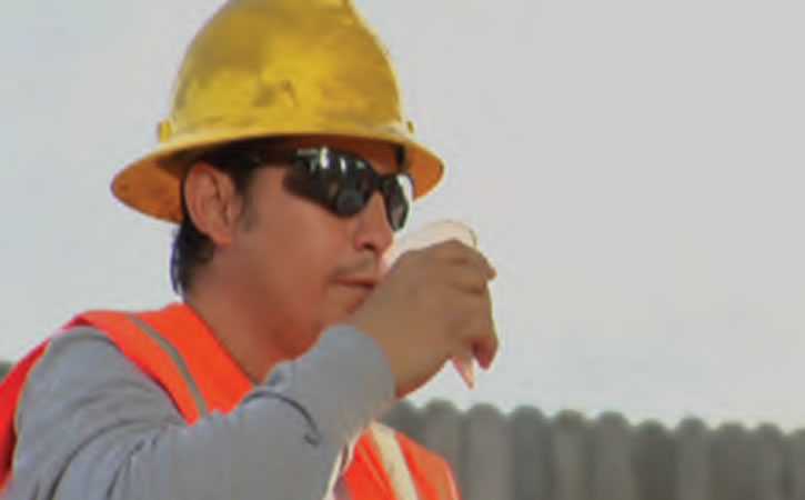 A Construction worker takes a drink of water.