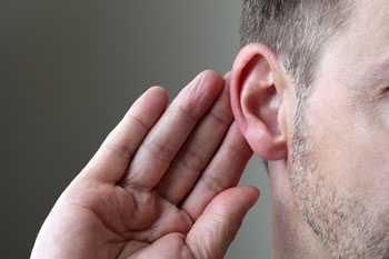 	Image showing a person with his hand behind his ear trying to hear