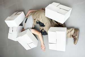 	Employee lies on floor covered by boxes, as if the worker had fallen, and the boxes landed on him or her.