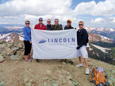 Lincoln industries employees atop a mountain