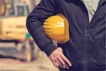 	Yellow hard hat underneath a workers arm