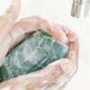 Primer plano de un par de manos humanas lavándose con jabón