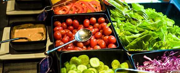 A variety of fresh vegetables on a salad bar