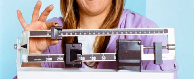 A woman checking her weight on a scale.