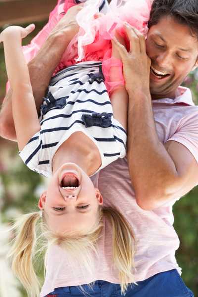 Dad holding daughter upside-down