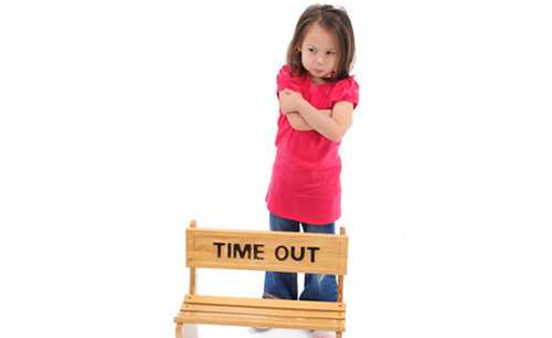 Girl standing in front of time out chair