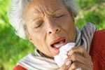 Older woman sneezing