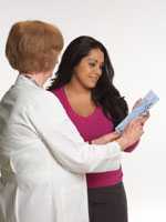 Woman looking at paperwork with doctor