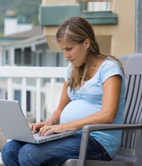 A pregnant woman using a laptop