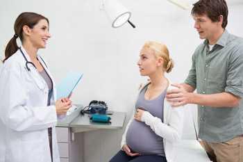 Pregnant woman talking with her doctor about medication