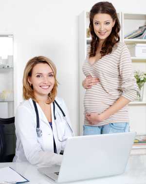 Pregnant woman talking with her doctor about medication use.