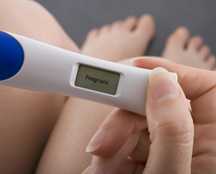 photo of a woman holding a pregnancy test, testing positive