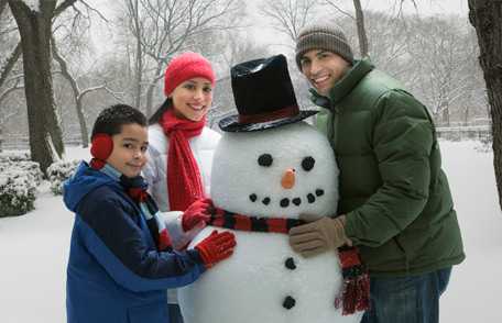 Familia hispana hace un muñeco de nieve