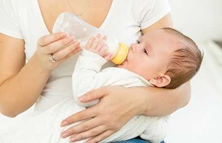 Bebé toma leche de un biberón.