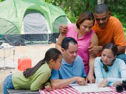 Familia de camping mirando un mapa