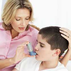 Madre ayudando a su hijo a utilizar un inhalador