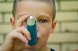 Un niño usando un inhalador