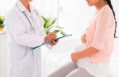 Una mujer embarazada hablando con el médico