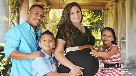 Foto de marido y mujer embarazada con dos hijos