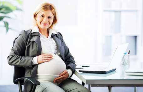 Mujer embarazada que se mantiene segura en el trabajo