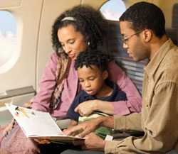 Padres leyendo un libro junto a su hijo durante un viaje en avión