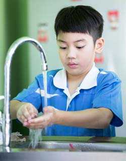 Un niño se lava las manos.