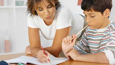 Madre ayudando a su hijo (11-12) con la tarea