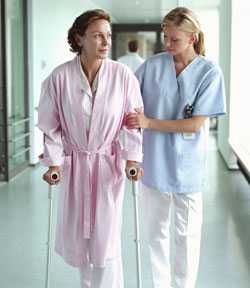 Mujer caminando por un pasillo del hospital con la enfermera
