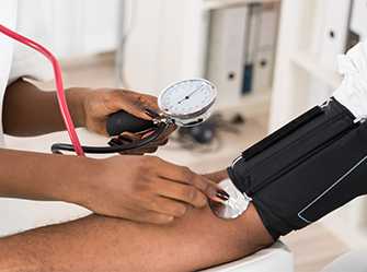 Foto: Una enfermera que controla la presión arterial de una mujer afroamericana