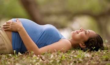Pregnant woman lying on grass