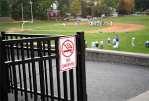 Photo of a practice field with a no smoking sign