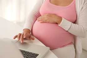	Pregnant woman on laptop.