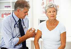 Doctor vaccinating senior woman