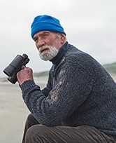 Older gentlemen on beach with binoculars 