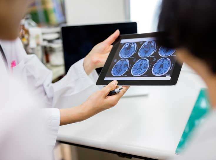Medical staff viewing brain images on an xray