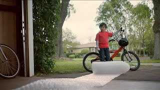 Boy on bike looking at roll of bubble wrap